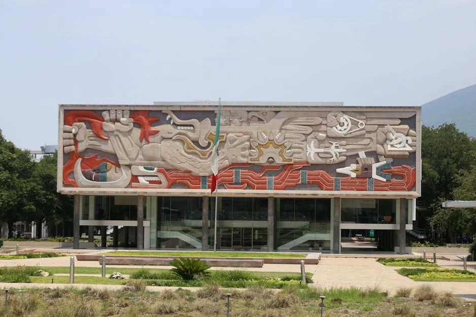 The sun reflecting off the glass facade of a modern high-rise university building